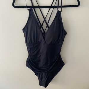 Women’s black one piece bathing suit with cross straps in the back